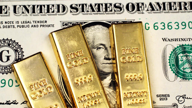 American one dollar bill with three small gold bars 